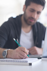 Image showing student in school library using laptop for research