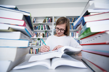 Image showing female student study in library, using tablet and searching for 