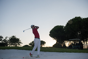 Image showing golfer hitting a sand bunker shot on sunset