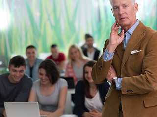 Image showing portrait of in teacher in classroom with students group in backg