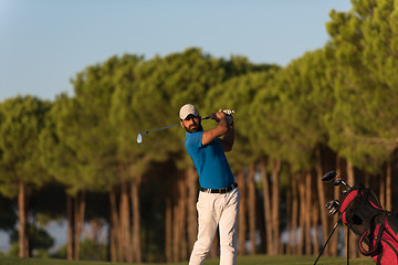 Image showing golfer hitting a sand bunker shot on sunset