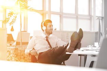 Image showing relaxed young businessman first at workplace at early morning