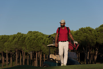 Image showing golfer  walking and carrying golf  bag