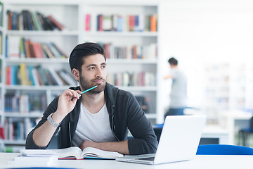 Image showing student in school library using laptop for research