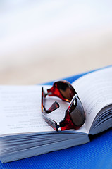 Image showing Sunglasses and book on beach chair