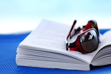 Image showing Sunglasses and book on beach chair