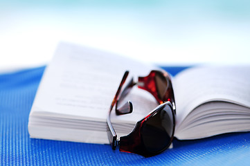 Image showing Sunglasses and book on beach chair