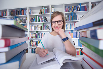 Image showing female student study in library, using tablet and searching for 