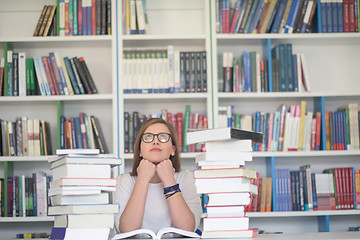 Image showing female student study in library, using tablet and searching for 