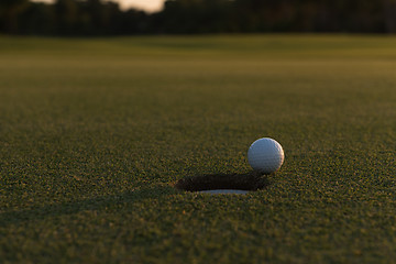 Image showing golf ball on edge of  the hole