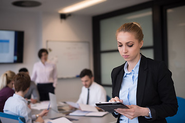 Image showing business woman working on tablet at meeting room