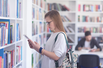 Image showing famale student selecting book to read in library