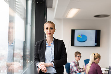 Image showing portrait of young business woman at office with team on meeting 