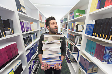 Image showing Student holding lot of books in school library