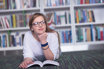 Image showing female student study in library, using tablet and searching for 