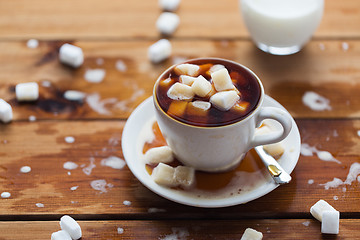 Image showing close up of sugar in coffee cup on wooden table