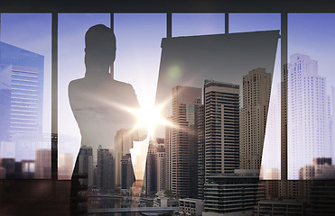 Image showing silhouette of woman with flipboard over city