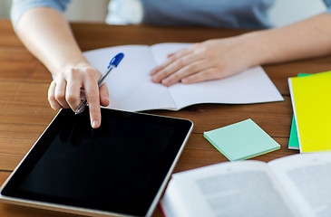 Image showing close up of student with tablet pc and notebook