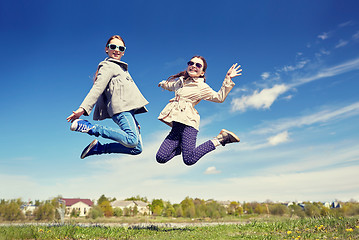 Image showing happy little girls jumping high outdoors