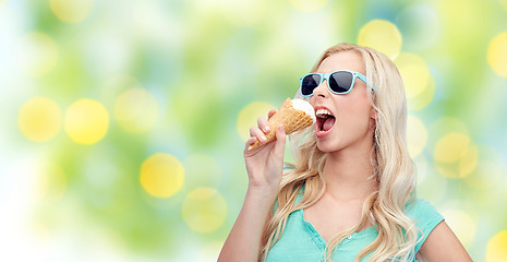 Image showing happy young woman in sunglasses eating ice cream