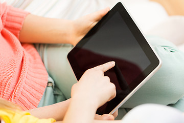 Image showing close up of young women with tablet pc at home