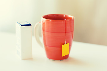 Image showing close up of sweetener and tea cup on table