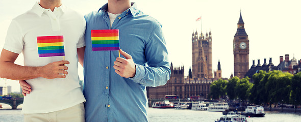 Image showing close up of male gay couple with rainbow flags