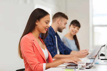 Image showing happy african woman over creative team at office