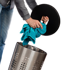 Image showing Young man putting a dirty towel in a laundry basket