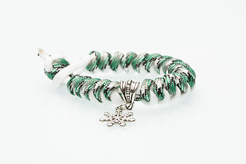 Image showing green braided bracelet on white background. snowflake