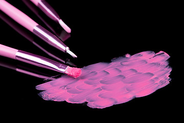 Image showing lipstick with a brush make-up on black 