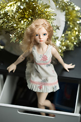 Image showing doll in a box on a light background. blurred rear plan