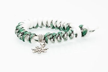 Image showing green braided bracelet on white background. snowflake