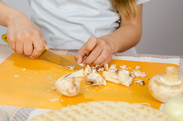 Image showing Close-up of childrens hands, cutting knife mushrooms on a cutting board