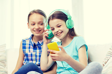 Image showing happy girls with smartphone and headphones