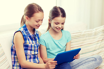 Image showing happy girls with tablet pc sitting on sofa at home