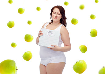 Image showing happy young plus size woman holding scales