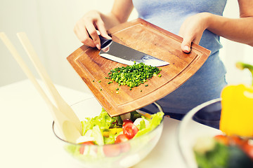 Image showing close up of woman with chopped onion cooking salad