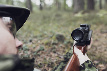 Image showing close up of soldier or hunter with gun in forest