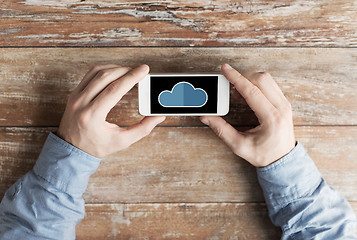 Image showing close up of male hands with cloud on smartphone