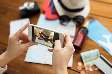 Image showing close up of woman with smartphone and travel stuff