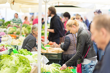 Image showing Woman buying vegetable at local food market. 