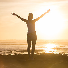 Image showing Free woman enjoying freedom on beach at sunset.