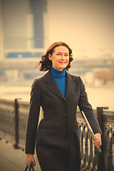 Image showing smiling middle-aged woman in a dark coat