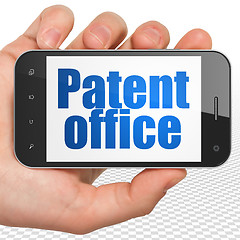 Image showing Law concept: Hand Holding Smartphone with Patent Office on display