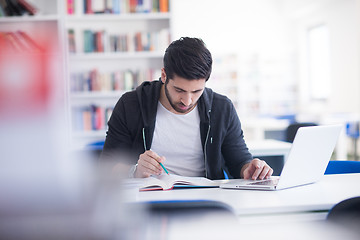 Image showing student in school library using laptop for research