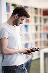 Image showing student in school library using tablet for research