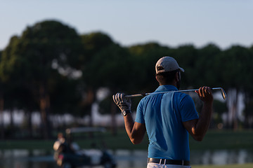 Image showing golfer from back at course looking to hole in distance