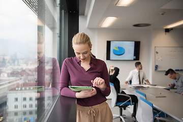 Image showing blonde businesswoman working on tablet at office
