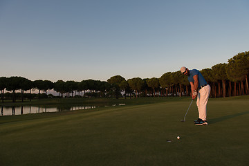 Image showing golfer  hitting shot at golf course